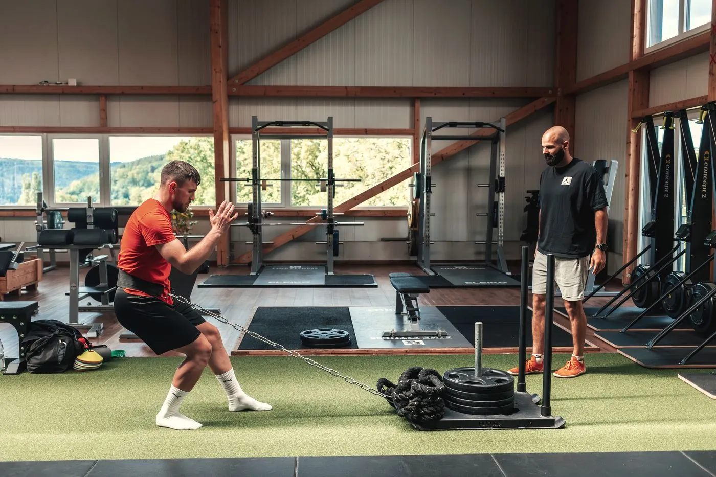 Athlet beim Kettensquat unter Anleitung von Coach Ivan